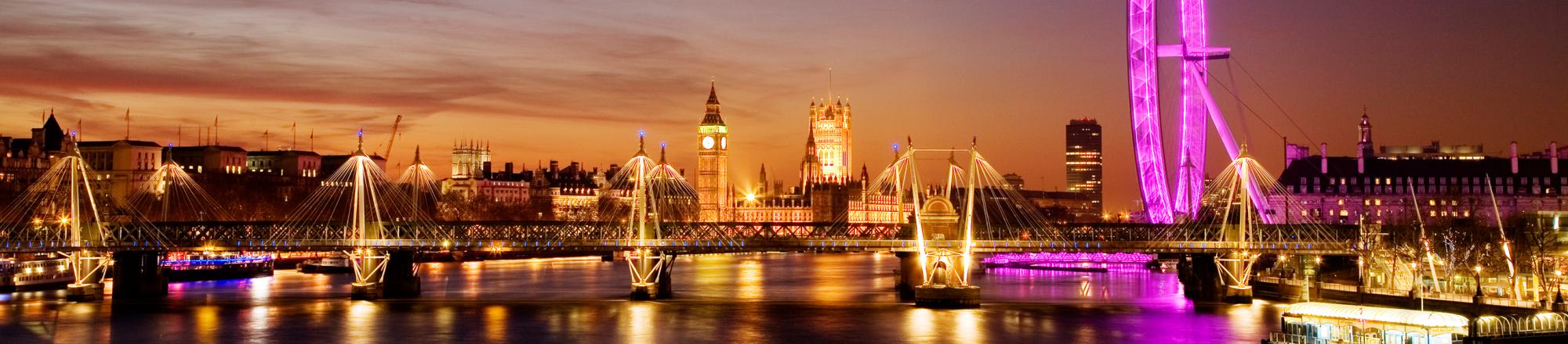 View along the Thames: Big Ben, Westminster, the London Eye, South Bank and the Hungerford Bridge lit up at dusk. 