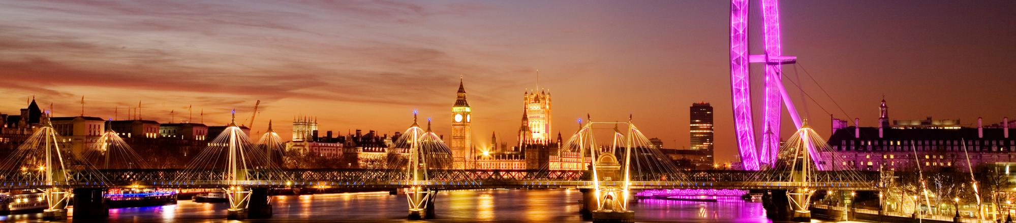 View along the Thames: Big Ben, Westminster, the London Eye, South Bank and the Hungerford Bridge lit up at dusk. 